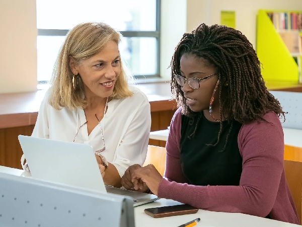 Young woman learning skills from another woman